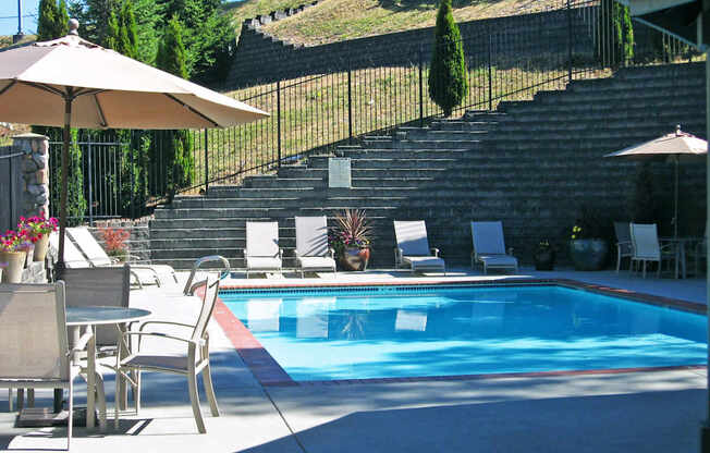 A pool with a table and chairs around it.