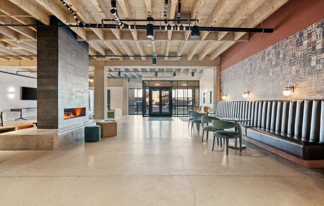 the lobby of a building with a fireplace and tables and chairs
