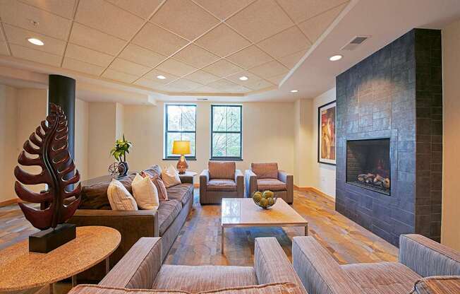 A living room with a sofa, chairs, a fireplace and a large sculpture.