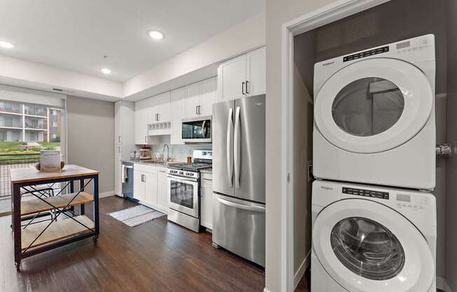 A modern kitchen with stainless steel appliances and a wooden table.