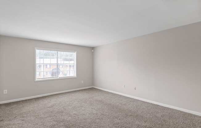 an empty room with carpet and a window