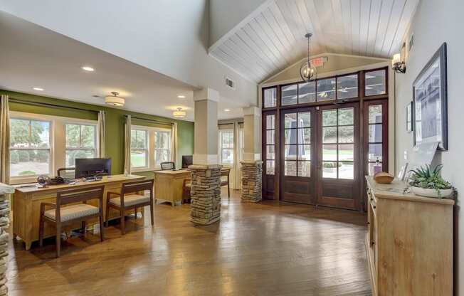 the home has a large office with a wood floor and glass doors