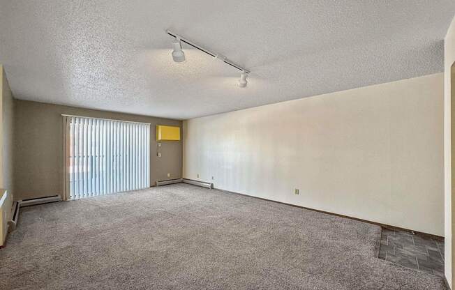 an empty living room with blinds on the window