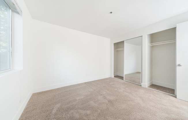 a room with carpet and white walls and sliding glass doors