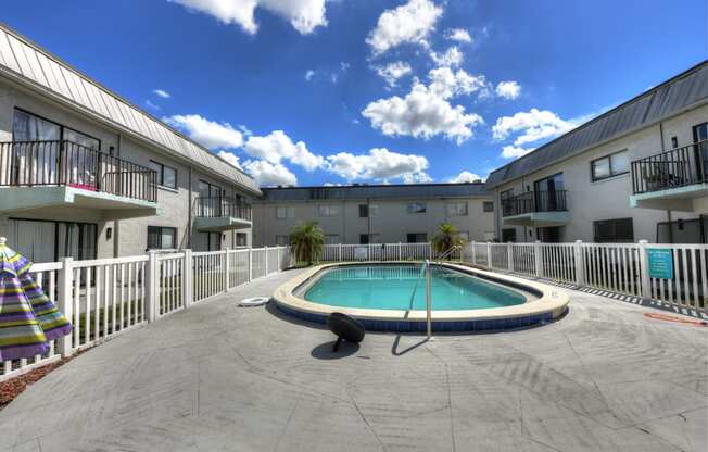 A swimming pool in a courtyard surrounded by buildings.