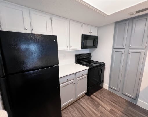 a kitchen with black appliances and white cabinets