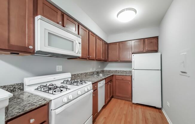 a kitchen with brown cabinets and white appliances