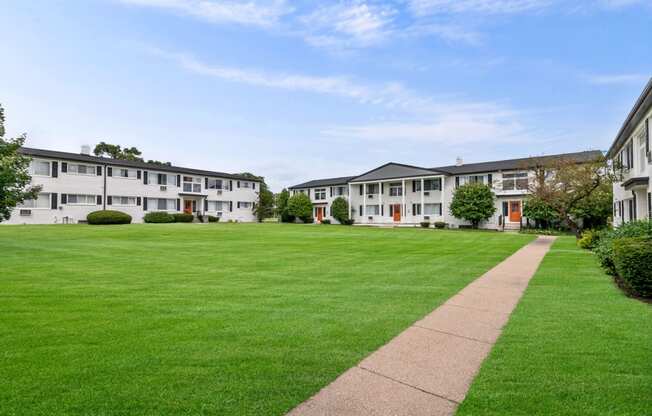 a lawn in front of a row of apartment buildings