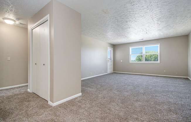 Omaha, NE Maple Ridge Apartment. A bedroom with carpet and a door to a bathroom