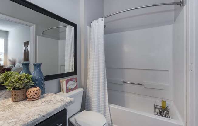 a bathroom with gray walls and a white shower curtain