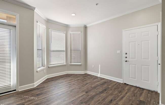 an empty living room with a white door and windows at The Verandah, Austin, TX, 78726