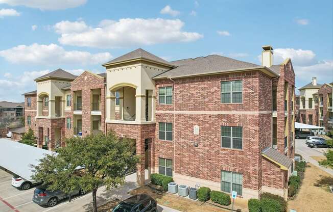 A large brick building with a parking lot in front.