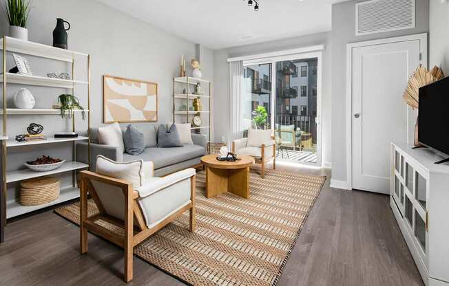A living room with a grey couch, a wooden chair, and a wooden coffee table.