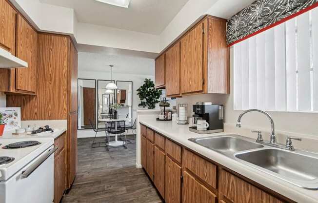 A kitchen with wooden cabinets and a white stove top oven.