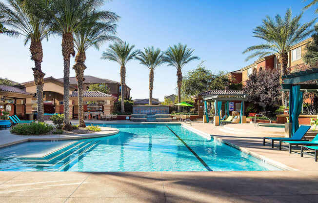 a swimming pool with palm trees and buildings in the background