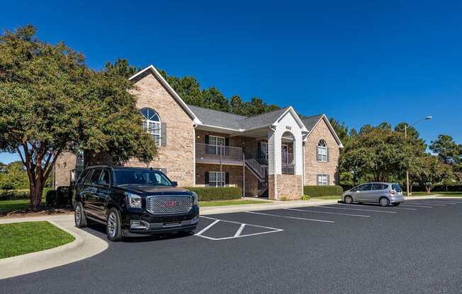 A black SUV is parked in a parking lot in front of a building.