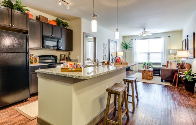 an open kitchen with a large island with bar stools