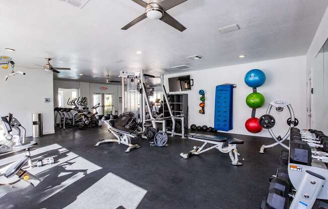 A well-equipped gym with a variety of exercise machines and weights.