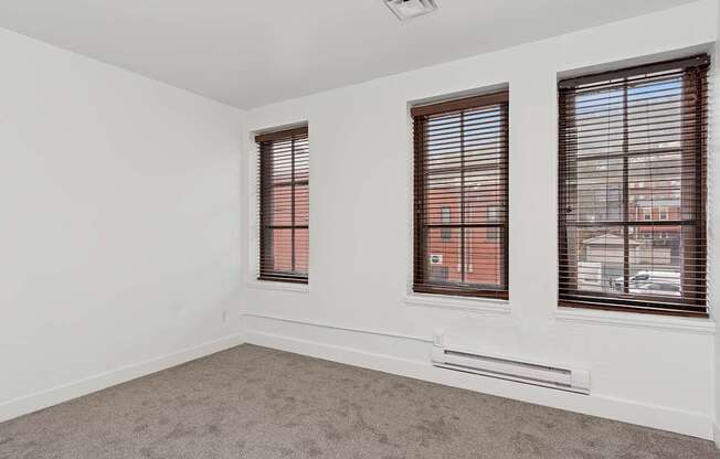 A room with two windows and a carpeted floor.