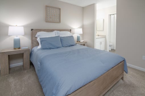 Model Apartment bedroom with a bed and two night stands and a bathroom