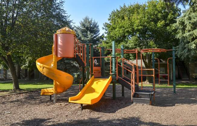 a playground with a slide and other toys in a park