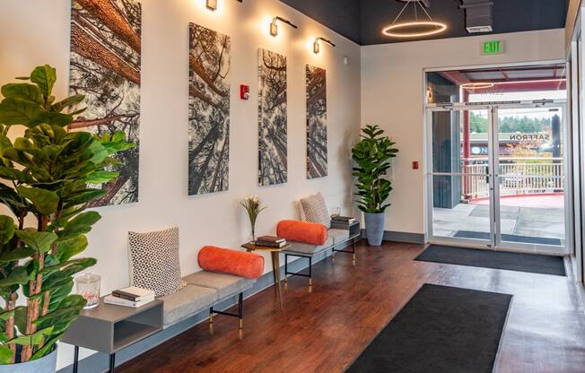 a lobby with chairs and plants and a glass door