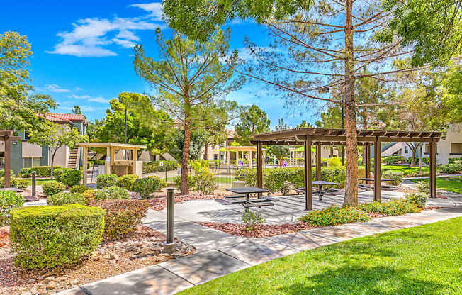 A sunny day at a park with a pavilion and trees.