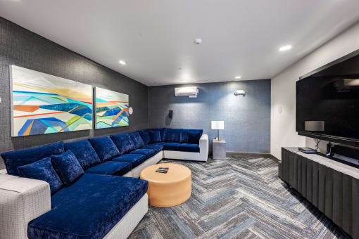 a living room with blue couches and a television