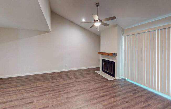 A room with a fireplace and a ceiling fan.