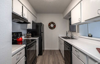 a kitchen with white cabinets and black appliances