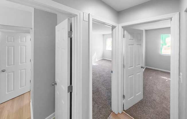 an empty room with white doors and a carpeted floor