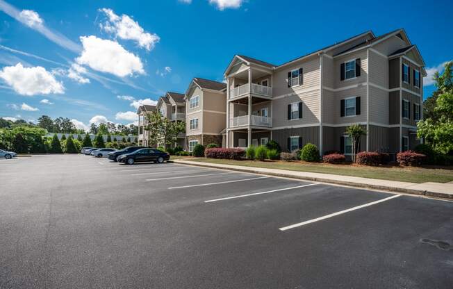 Three-story residential building with surface lot parking at Riverstone apartments for rent in Macon, GA