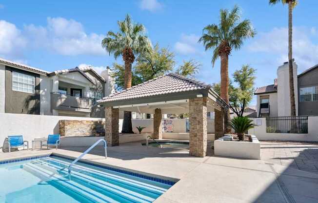 A pool with a slide and a gazebo in the middle of it.