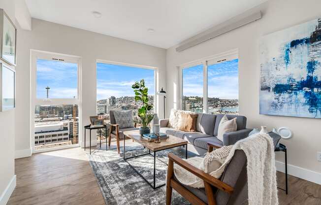 an open living room with a view of the city and a couch and chairs  at Oslo, Seattle, Washington