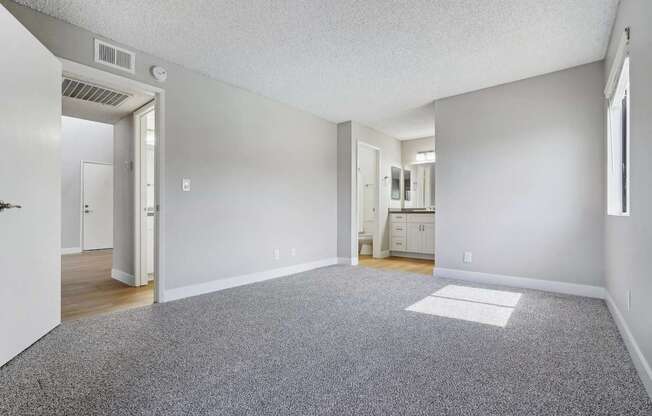 an empty living room with gray carpet and white walls