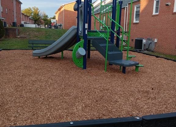 A playground with a green slide and a blue and green climbing frame.