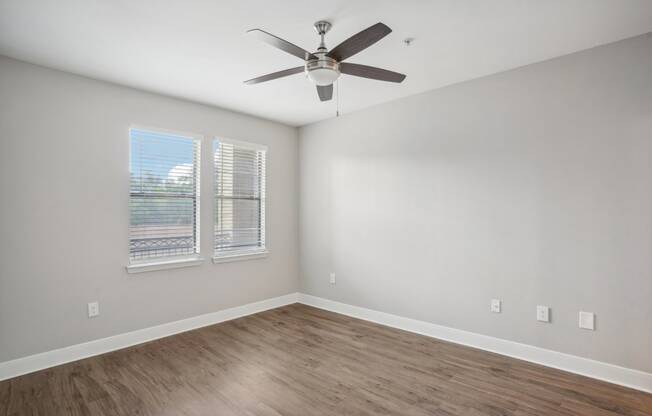 an empty living room with a ceiling fan and a window at The Verandah, Austin, TX