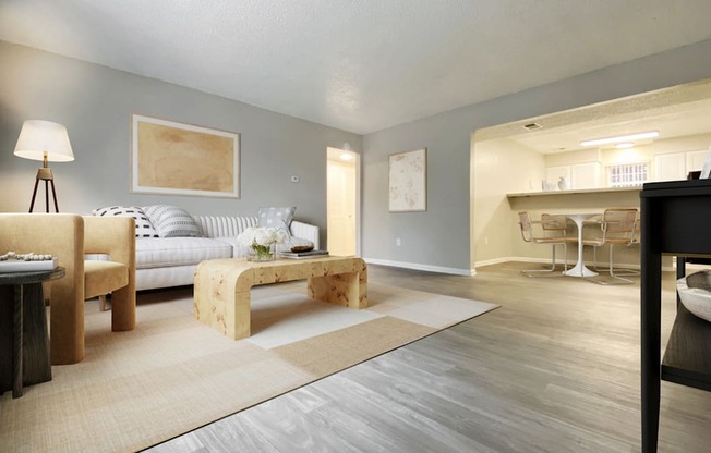 A modern living room with a grey sofa, a wooden table, and a rug.