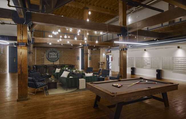 A pool table is in the middle of a room with a couch and chairs.