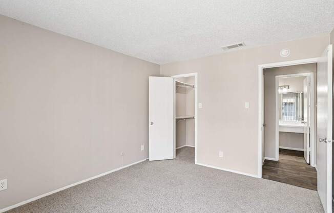 A5 bedroom looking toward the entrance and walk-in closet at Windridge on the Parkway apartments in Dallas, TX