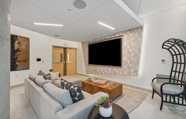 a living room with a couch and a television on the wall