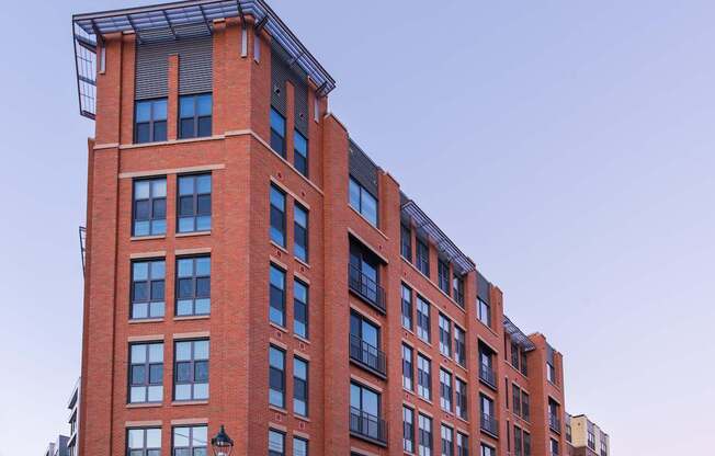 A tall red brick building with a black lamp post in front.