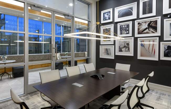 a conference room with a table and chairs and pictures on the wall