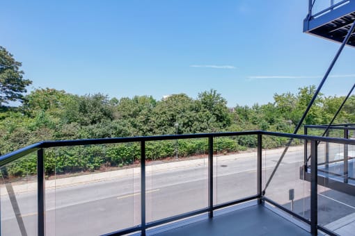 a balcony with a view of a street and trees