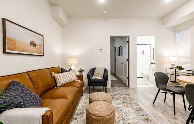 a living room with a brown couch and a dining room table