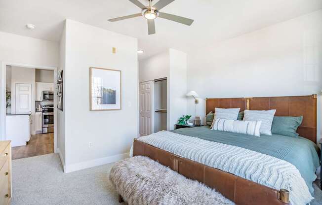 A bedroom with a large bed and a ceiling fan.