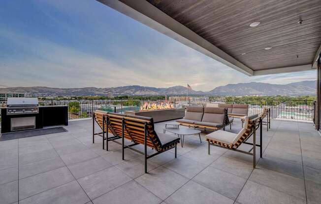 A patio with a table and chairs overlooking a mountain range.