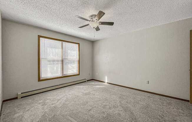 an empty living room with a ceiling fan and a window at Creekstone Falls, South Dakota, 57106