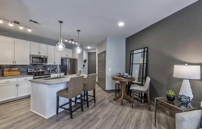 an open kitchen and living room with a dining room table and chairs