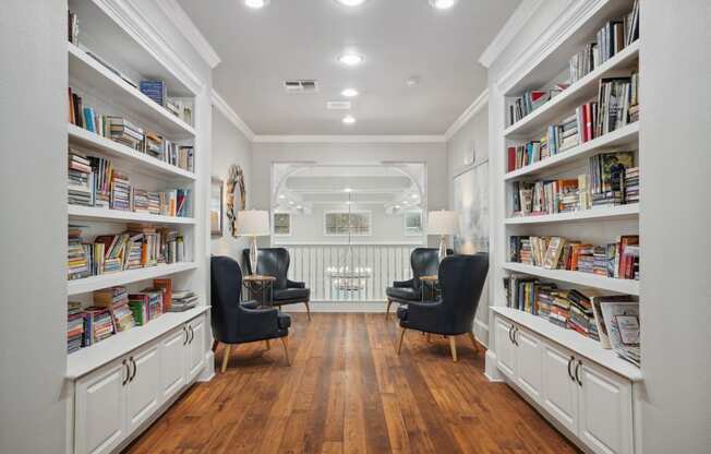 a living room filled with bookshelves and chairs